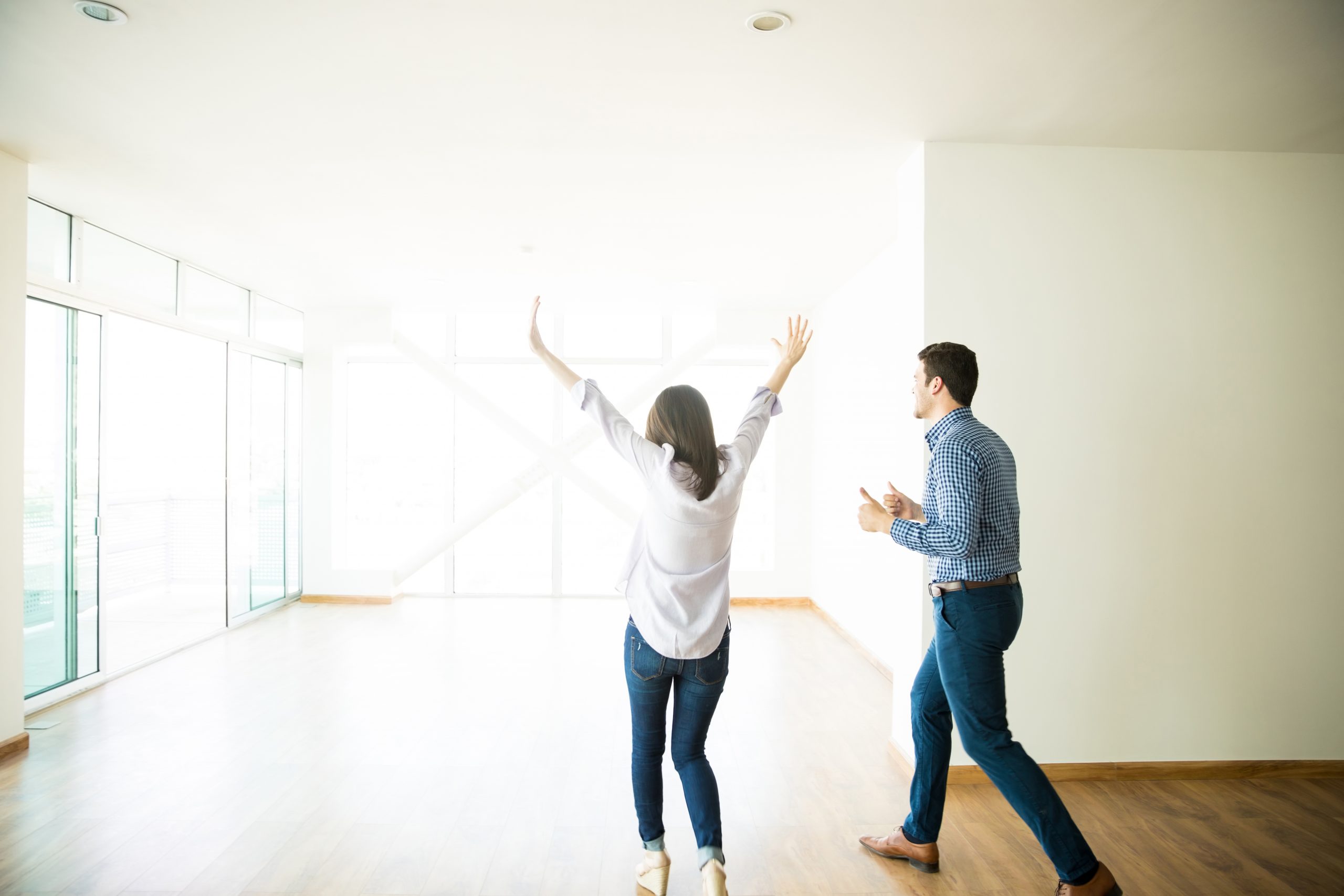 Excited mid adult man and woman entering into their new apartment